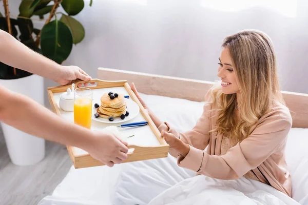 Man Giving Breakfast Tray Pancakes Orange Juice Smiling Girlfriend Bed — Stock Photo, Image