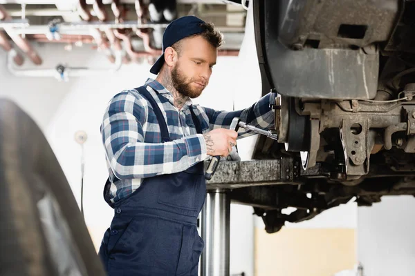 Young Technician Adjusting Wheel Hub Wrench Blurred Foreground — Stock Photo, Image