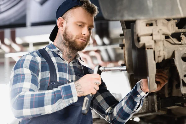 Young Mechanic Fixing Wheel Hub Wrench Blurred Foreground — Stock Photo, Image