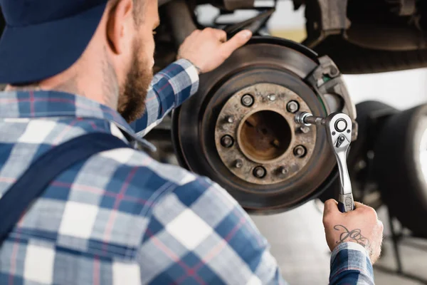 Back View Repairman Fixing Wheel Hub Wrench Blurred Foreground — Stock Photo, Image