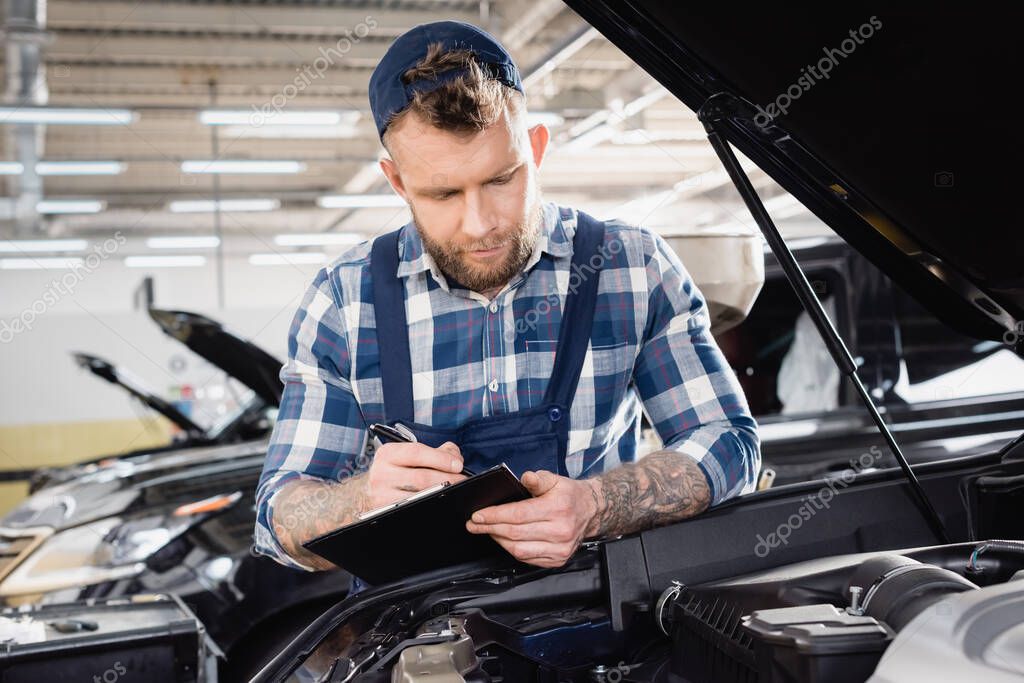 scrittura meccanica tatuata negli appunti vicino al vano motore dell'auto
