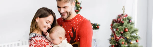 Glückliche Eltern Mit Baby Arm Der Nähe Des Geschmückten Weihnachtsbaums — Stockfoto