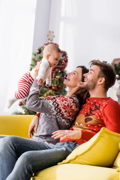 Mujer Feliz Sosteniendo Brazos Bebé Niño Cerca Marido Suéter Borrosa — Foto de Stock