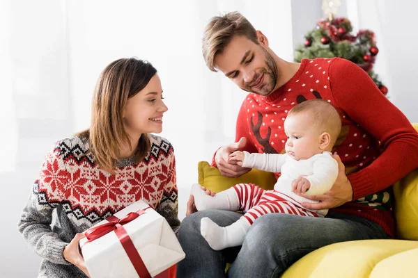 Feliz Madre Sosteniendo Regalo Navidad Envuelto Cerca Marido Hijo Bebé — Foto de Stock
