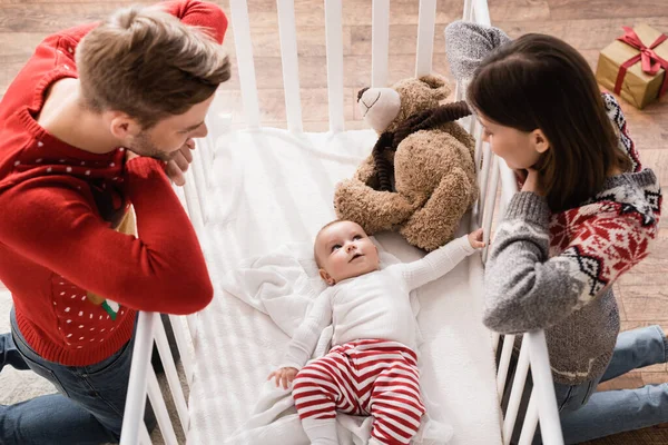 High Angle View Parents Standing Knees Looking Baby Boy Crib — Stock Photo, Image