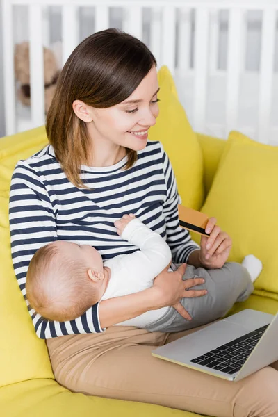 Smiling Woman Infant Son Holding Credit Card Laptop While Sitting — Stock Photo, Image
