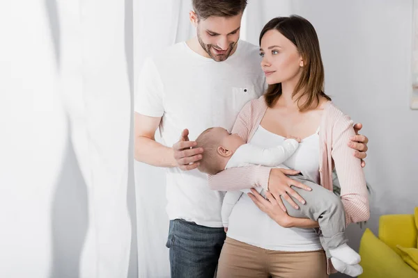 Starostlivá Žena Držení Náručí Kojenec Chlapec Blízkosti Manžela — Stock fotografie