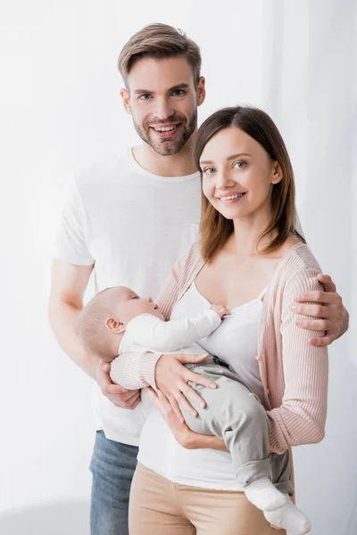 Sonriente Mujer Sosteniendo Brazos Infante Niño Cerca Feliz Marido — Foto de Stock