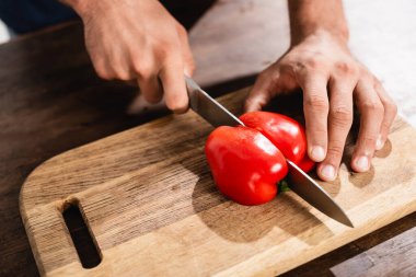 Ahşap kesme tahtasıyla dolma biber kesen adam manzarası. 