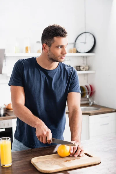 Jeune Homme Regardant Loin Tout Coupant Orange Près Verre Jus — Photo