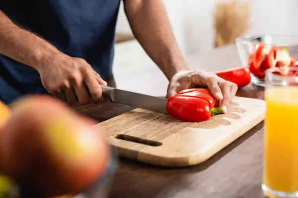 Cropped View Man Cutting Paprika Glass Orange Juice Blurred Foreground —  Fotos de Stock