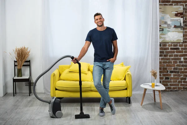 Pria Tersenyum Berdiri Dekat Vacuum Cleaner Ruang Tamu — Stok Foto