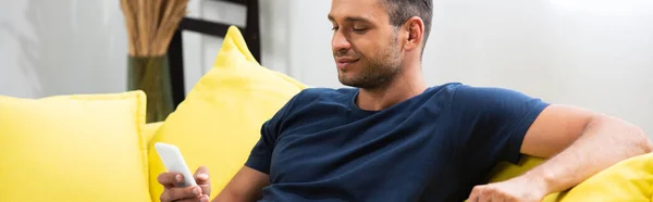 Young Man Using Smartphone Couch Home Banner — Stock Photo, Image