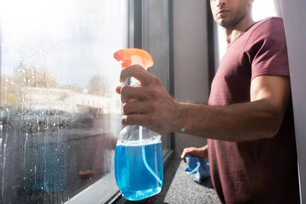 Cropped View Bottle Detergent Hand Man Rag Window Blurred Background — Stock fotografie