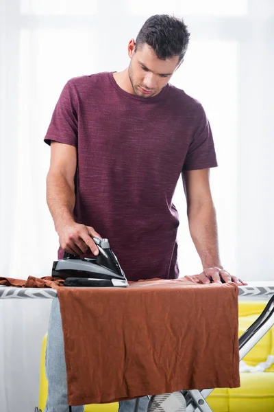 Ung Mand Strygning Shirt Båd Derhjemme - Stock-foto