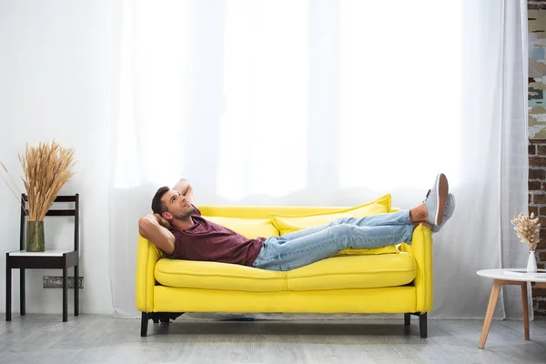 Sorrindo Homem Com Mãos Perto Cabeça Deitado Sofá Casa — Fotografia de Stock