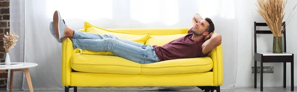 Smilende Mand Ser Mens Liggende Sofaen Derhjemme Banner - Stock-foto