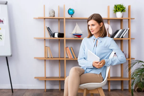 Psicóloga Feminina Com Tablet Digital Olhando Para Longe Enquanto Sentada — Fotografia de Stock