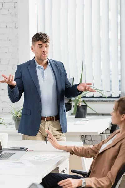 Businessman Gesturing While Talking Colleague Sitting Workplace Break Office — Stock Photo, Image