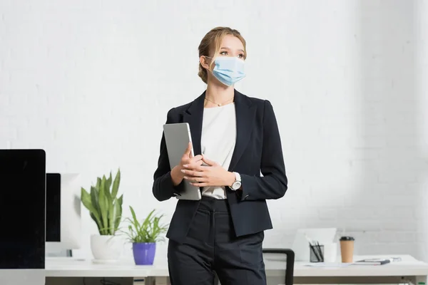 Esecutivo Femminile Maschera Medica Con Computer Portatile Guardando Altrove Mentre — Foto Stock