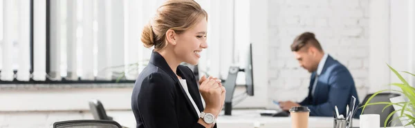 Glad Forretningskvinde Kigger Bærbar Computer Mens Sidder Arbejdspladsen Sløret Baggrund - Stock-foto