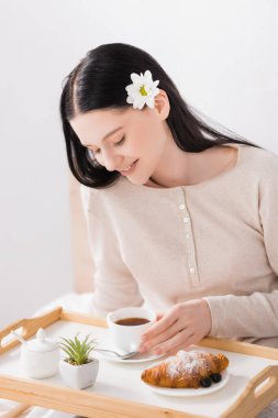 Vitiligo 'lu mutlu esmer kadın tepside kahvaltıya bakıyor. 