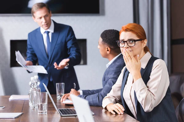 Scared Businesswoman Covering Mouth Hand Looking Camera While Sitting Blurred — Stock Photo, Image
