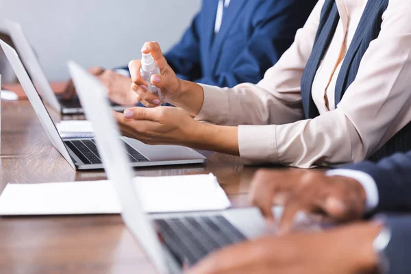 Cropped View Businesswoman Applying Sanitizer Hands Multicultural Colleagues Workplace Blurred — Stock Photo, Image