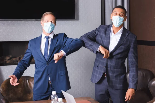 Багатокультурні Бізнесмени Медичних Масках Дивляться Камеру Вітаючи Один Одного Ліктями — стокове фото