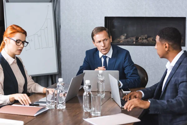 Serieuze Executive Praten Met Afrikaanse Amerikaanse Zakenman Tijdens Discussie Vergaderzaal — Stockfoto