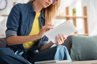 Bulanık arka planda dijital tablet kullanan genç bir kadın görüntüsü