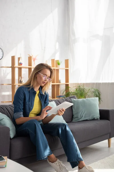 Ung Blond Kvinna Glasögon Med Digital Tablett När Sitter Soffan — Stockfoto