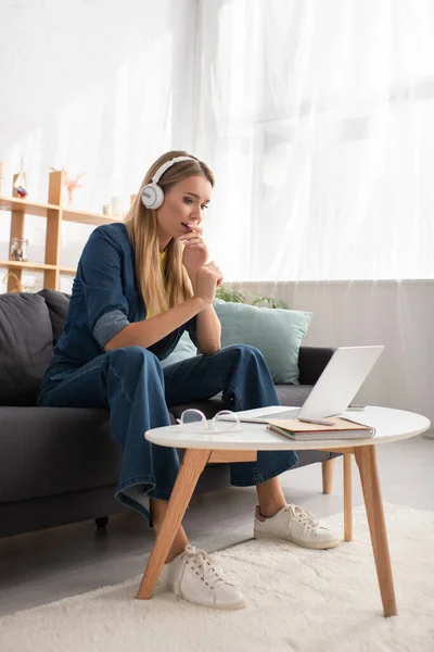 Full Length Scared Blonde Woman Headphones Looking Laptop While Sitting — Stock Photo, Image