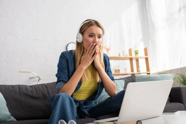 Frightened Blonde Woman Headphones Looking Computer While Sitting Couch Home — Stock Photo, Image