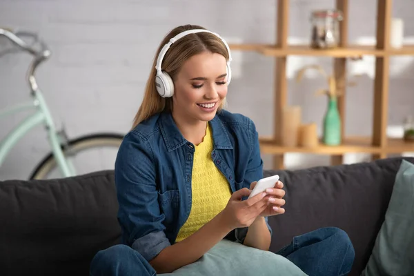 Jovem Alegre Mensagens Texto Smartphone Casa Fundo Embaçado — Fotografia de Stock