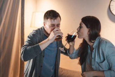 Alkol bağımlısı çift evde viski ve şarap içiyor.