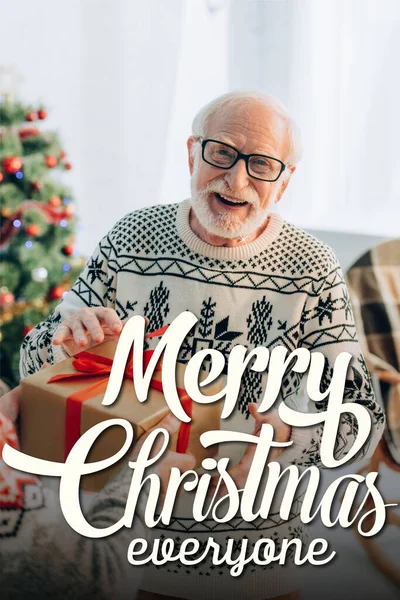 Happy Senior Man Receiving Gift Wife Merry Christmas Everyone Lettering — Stock Photo, Image