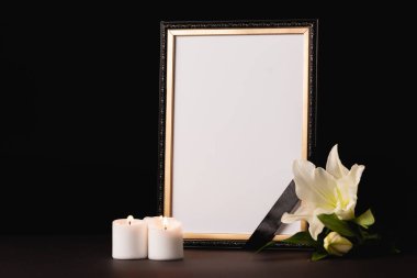 Lily, siyah arka planda kurdeleli mum ve ayna, cenaze konsepti.