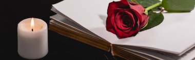 red rose on holy bible near candle on black background, funeral concept, banner clipart