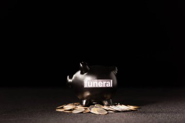 piggy bank with coins on black background, funeral concept clipart