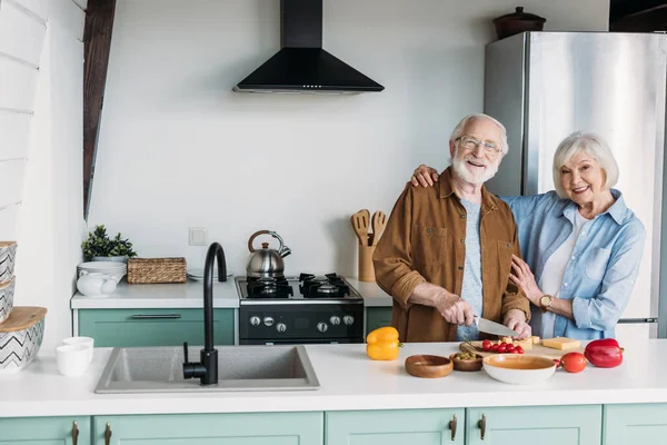 Sonriendo Esposa Mayor Mirando Cámara Mientras Abrazo Marido Cocina Cena — Foto de Stock