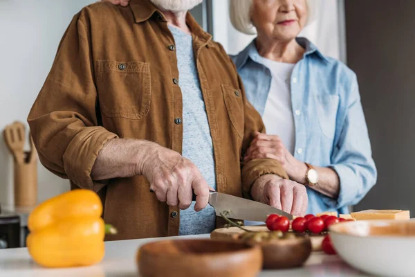 Visão Cortada Esposa Idosa Perto Marido Cortando Tomates Cereja Cozinha — Fotografia de Stock