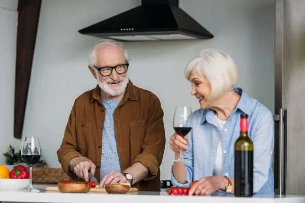 Leende Äldre Fru Med Vinglas Nära Make Matlagning Middag Kök — Stockfoto