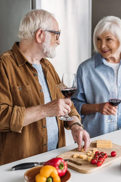 Zâmbind Cuplu Senior Pahare Vin Uitându Unul Altul Lângă Masă — Fotografie, imagine de stoc