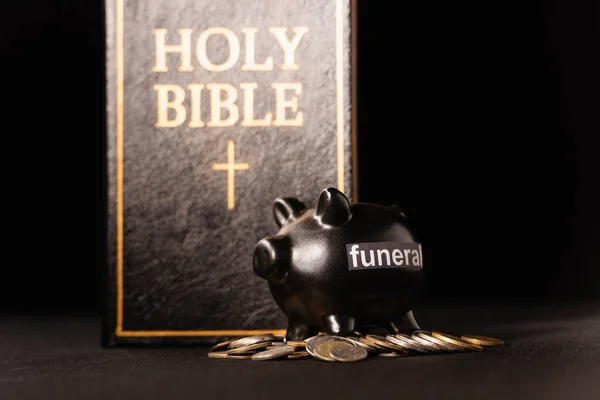 带有黑色背景的硬币和圣经的储蓄罐 葬礼概念 — 图库照片