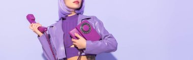 cropped view of young woman dressed in doll style with retro telephone on violet colorful background clipart