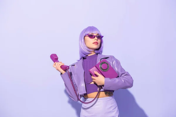 穿着洋娃娃风格的年轻女人 背景是紫罗兰色的复古电话 — 图库照片