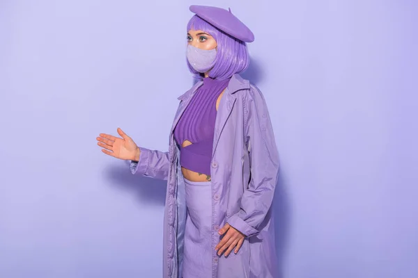 身着洋娃娃风格的年轻女子 戴着医疗面罩 头戴紫罗兰色背景的贝雷帽 — 图库照片