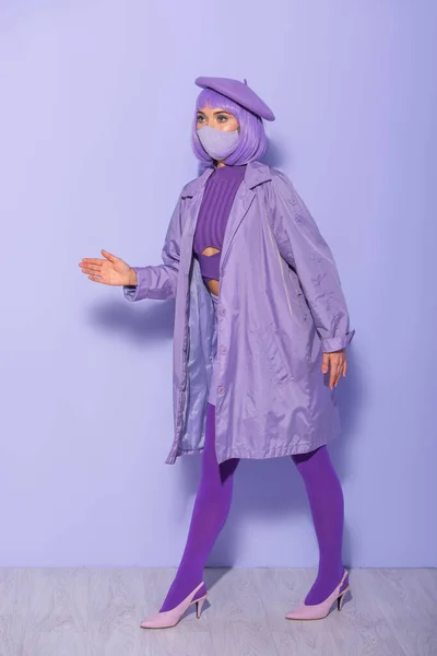 身着洋娃娃风格的年轻女子 戴着医疗面罩 头戴紫罗兰色背景的贝雷帽 — 图库照片