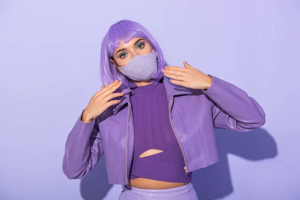 若い女性は紫のカラフルな背景にディスコボールと医療用マスクで人形のスタイルで身に着けています — ストック写真